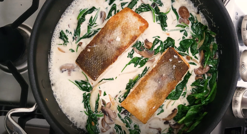 creamy salmon and spinach cooking in a pan